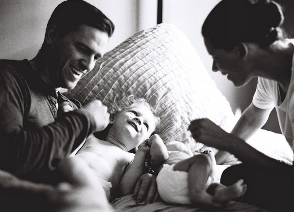 family playing together in bed at their family photography shoot